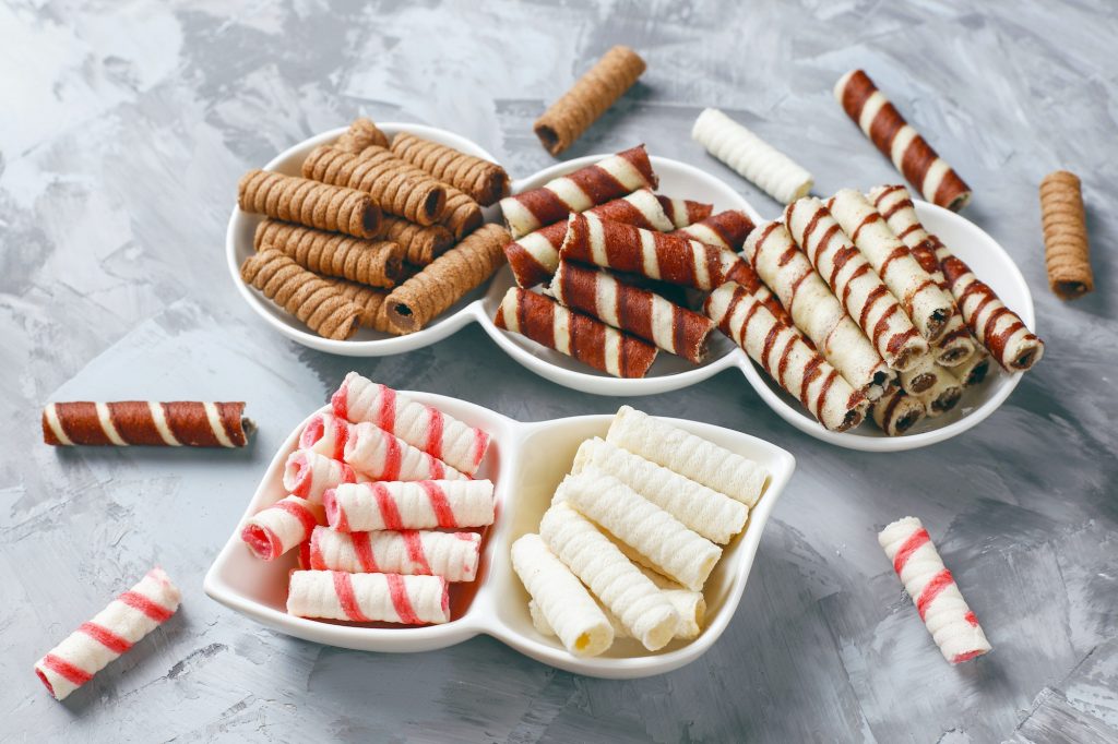 Various waffle rolls in ceramic plates,top view.